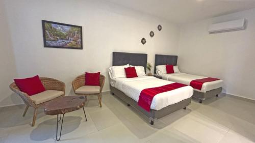a bedroom with two beds and a table and chairs at HOTEL SOÍ BACALAR in Bacalar