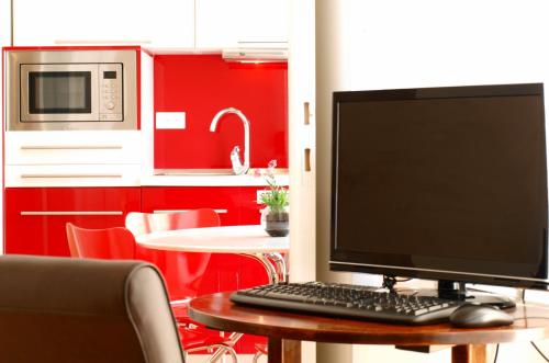 a computer monitor sitting on a table in a kitchen at Miró Studio Apartments Dubrovnik in Dubrovnik