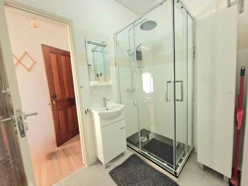 a bathroom with a glass shower and a sink at Arrifana Sea Stay in Aljezur