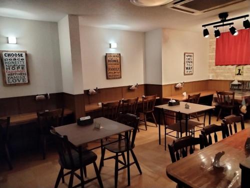 a restaurant with tables and chairs in a room at Guest House Bamboo in Morioka