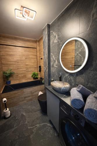 a bathroom with a sink and a tub and a mirror at Fly & Stay Otopeni Airport - Self Check-in in Otopeni