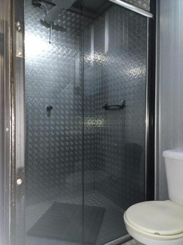 a shower stall with a toilet in a bathroom at Pousada Flay 7 minutos do Aeroporto de Florianópolis in Florianópolis