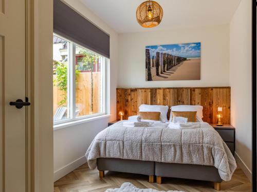 a bedroom with a bed and a large window at Dorpskaemer in Warmenhuizen