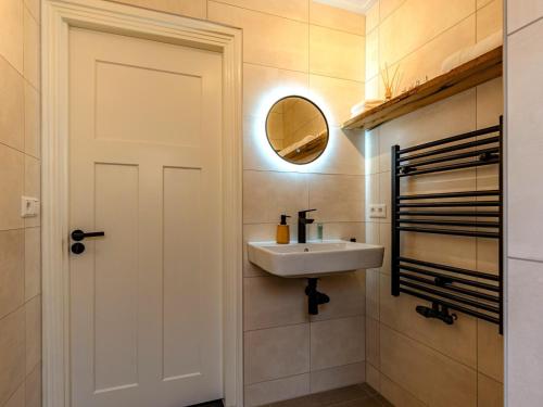 a bathroom with a sink and a mirror at Dorpskaemer in Warmenhuizen