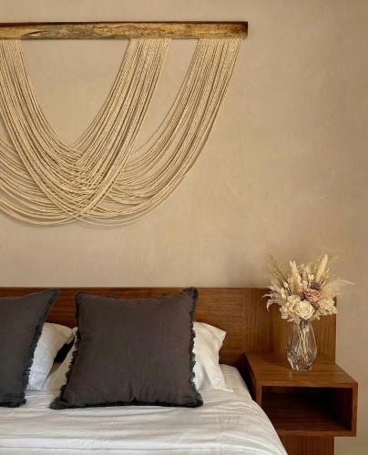 a bedroom with a bed with a vase of flowers at Casa Florentina in Tulum