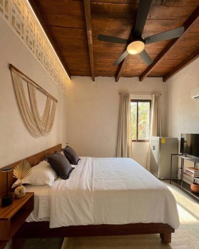 a bedroom with a bed and a ceiling fan at Casa Florentina in Tulum