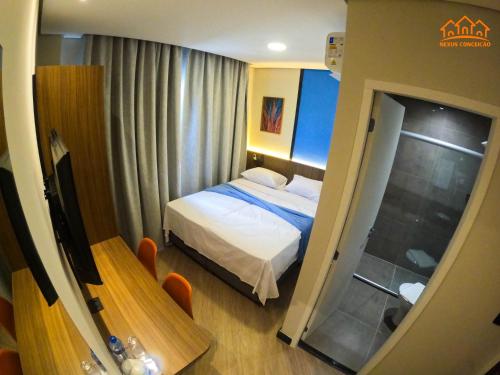 a small bedroom with a bed and a window at Nexus Conceição in São Paulo