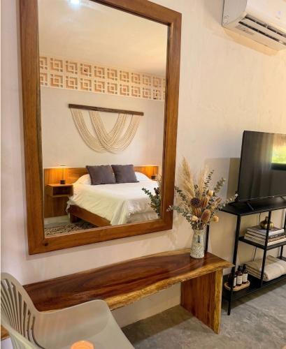 a bedroom with a bed and a mirror at Casa Florentina in Tulum
