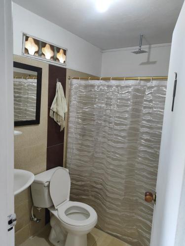 a bathroom with a toilet and a shower curtain at Finca Cercanías Marinilla - Casa Campestre in Marinilla