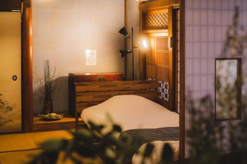 a room with a bed in a room with a mirror at 城ヶ島 浦ノ間邸 デザイナーズ古民家サウナヴィラ 富士山ビューBBqテラス付 in Miura