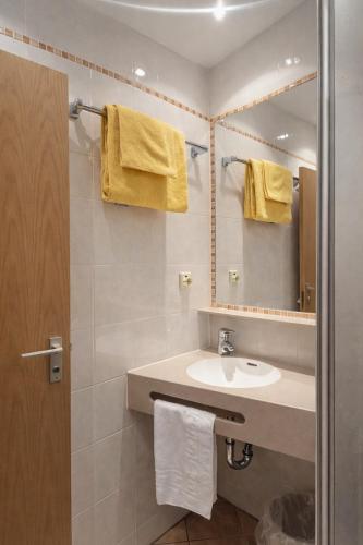 a bathroom with a sink and a mirror at Hotel Wendelstein München City in Munich
