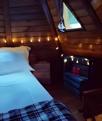 a bedroom with a bed with lights on it at Diamond Cabin in the Forest | Hot Tub | AC | Fire Pit in Gonçalves