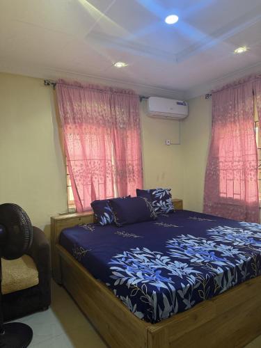 a bedroom with a bed and two windows at CEO Da Gracia Hotel, Irewon, Ijebu Ode in Ijebu Ode