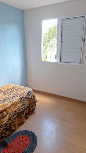 a bedroom with a bed and a window and a rug at Bélgica in Presidente Prudente