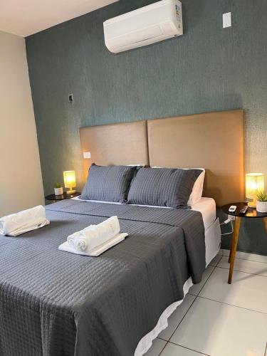 a bedroom with two beds with towels on them at Apto Master a 30m da Praça da Sé - Norões Residence in Crato