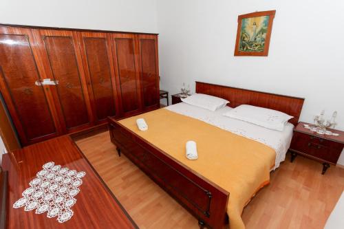 a bedroom with a large bed and wooden furniture at Apartment Mandre 4105a in Kolan