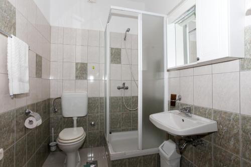 a bathroom with a toilet and a sink and a shower at Apartment Mandre 4105a in Kolan
