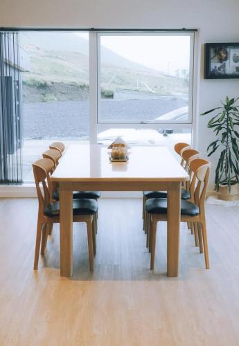 a dining room table with chairs and a large window at High end 3 BR Spacious Villa for 6 guests in Norðskáli