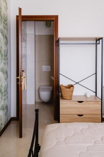 a bedroom with a door open to a bathroom with a toilet at Appartamento Melo Grano in Tuoro sul Trasimeno