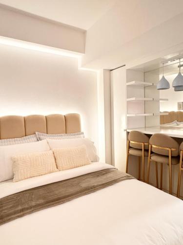 a bedroom with a large bed and a table at Cloud Haven Suite at Azure North Pampanga in San Fernando