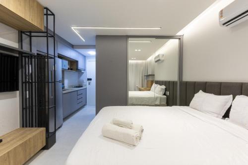 a bedroom with a large white bed with towels on it at City House 204 in Barreiras