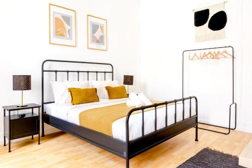 a bedroom with a black and white bed with yellow pillows at Bica Palace - Residence in Center of Lisbon in Lisbon