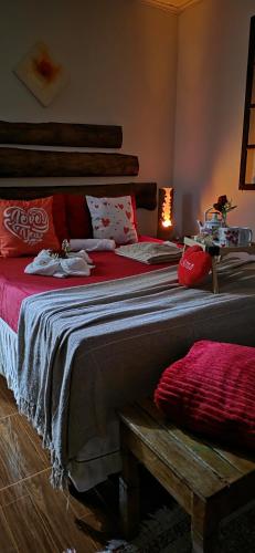 a bedroom with a large bed with red sheets at Casa da Lu in Macaé