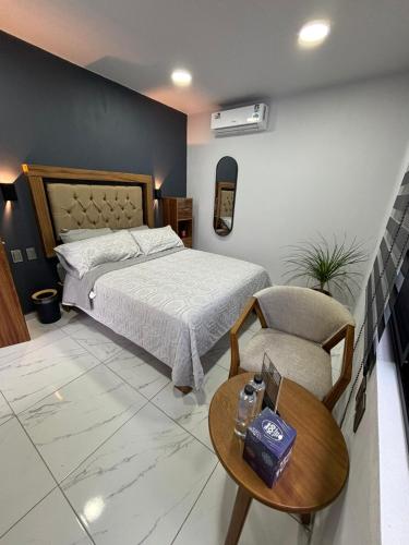 a bedroom with a bed and a table and a chair at Hotel Casa FRALO in Atotonilco el Alto