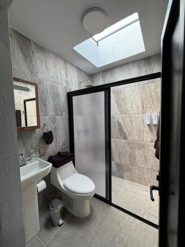 a bathroom with a toilet and a sink and a shower at Hotel Casa FRALO in Atotonilco el Alto