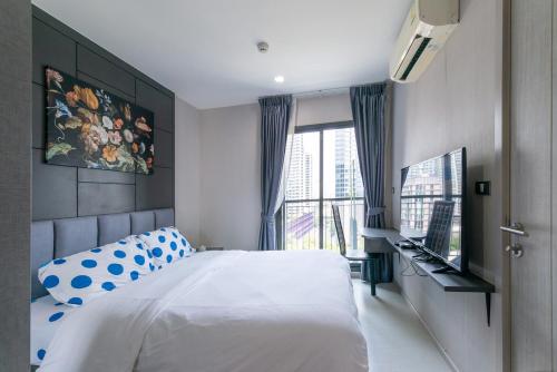 a bedroom with a large white bed and a window at Upscale Apartment With Train Access Bts Thonglor in Bangkok