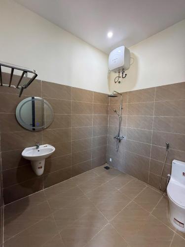 a bathroom with a toilet and a sink and a mirror at Trâm Anh Hotel in Kon Von Kla
