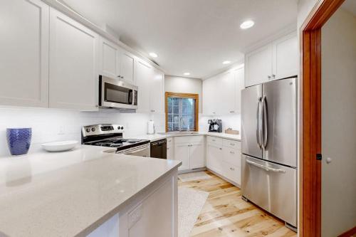 a kitchen with white cabinets and a stainless steel refrigerator at Warm & Inviting in Boise
