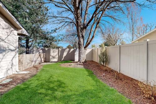 a fence with a tree in a yard at Warm & Inviting in Boise
