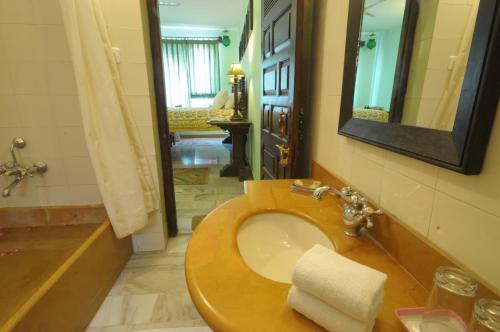 a bathroom with a toilet and a sink with a mirror at Haveli Inn Pal in Jodhpur