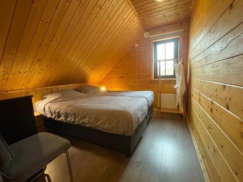 a bedroom with a bed in a wooden cabin at Forest Villa, Rural Twente in Den Ham