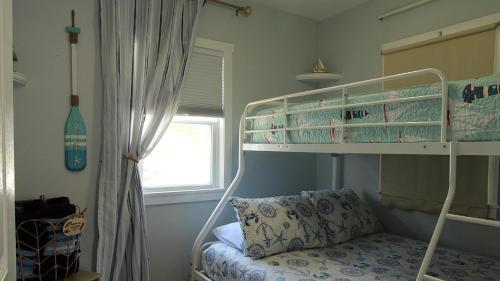 a bedroom with a bunk bed with a pillow next to a window at Shell Shack in Villas
