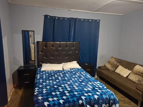 a bedroom with a bed and a couch at Mi casa in Ciudad Juárez