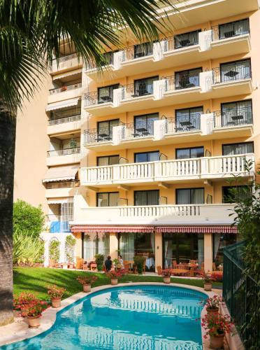 un hôtel avec une piscine devant un immeuble dans l'établissement Sun Riviera Hotel, à Cannes