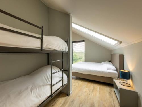 two bunk beds in a room with a window at Villa with Heated Pool, Sauna in Aalten
