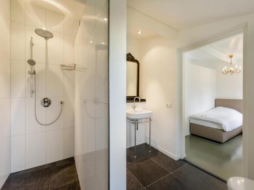 a bathroom with a shower and a sink and a bed at Achterhoek Estate with Private Pool in Aalten