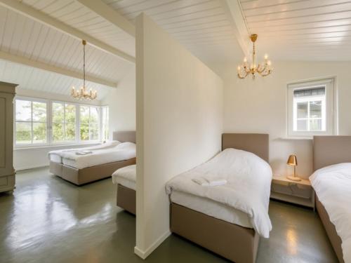 two beds in a room with white walls at Achterhoek Estate with Private Pool in Aalten