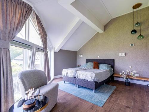 a bedroom with a bed and a chair at Water Villa, Sauna & Beach in Sibculo