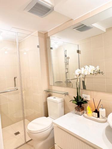 a bathroom with a toilet and a glass shower at Cloud Haven Suite at Azure North Pampanga in San Fernando