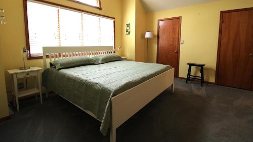 a bedroom with a bed with a green comforter at Pet Friendly And Steps To The Bay in Villas