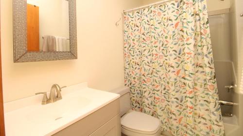 a bathroom with a shower curtain with a toilet and a sink at Pet Friendly And Steps To The Bay in Villas