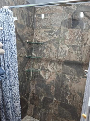 a shower with a glass door in a bathroom at Mi casa in Ciudad Juárez