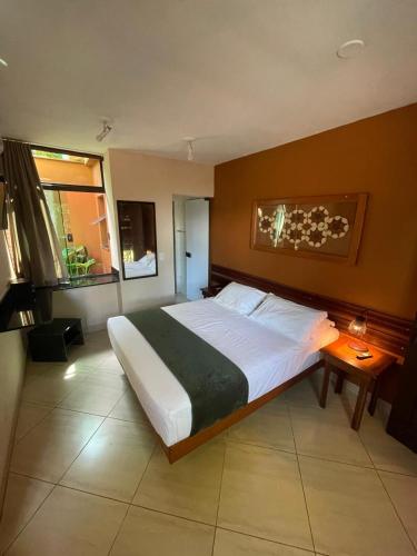 a bedroom with a large bed and a window at Pousada Sol e Cia Tur in Caraguatatuba