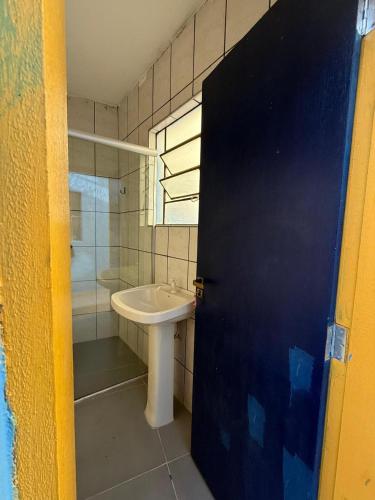 a bathroom with a sink and a shower at Oxx Hostel Quarto 3 in Congonhas