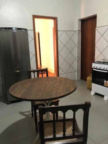 a wooden table and two chairs in a kitchen at Oxx Hostel Quarto 3 in Congonhas