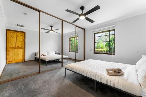a bedroom with a bed and a ceiling fan at Private 4BR Garden Haven - Spacious & Serene in Mawson Lakes